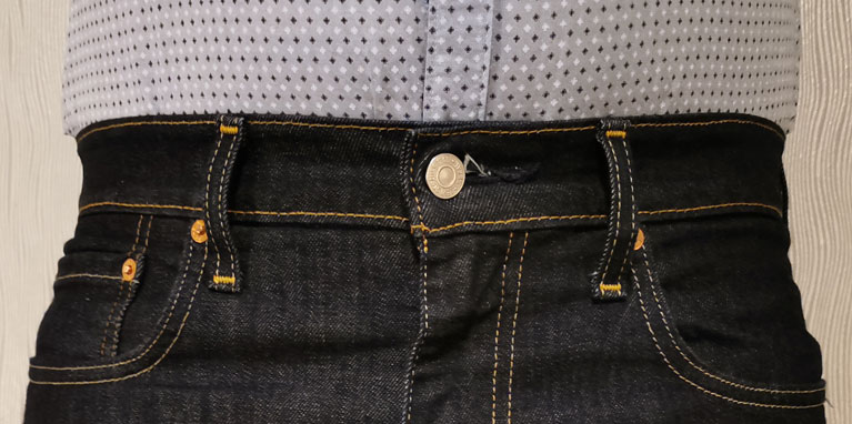Proper waist fit for jeans is snug around the waist