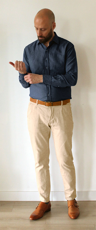 Man wearing navy dress shirt with khaki pants